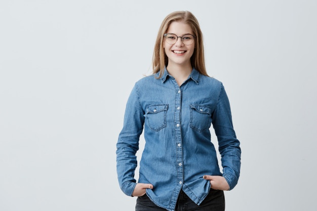 People, beauty and lifestyle concept. attractive sensual blonde woman with spectacles and wide smile dressed in denim shirt smiling broadly being happy to meet her best friend. joyful nice female